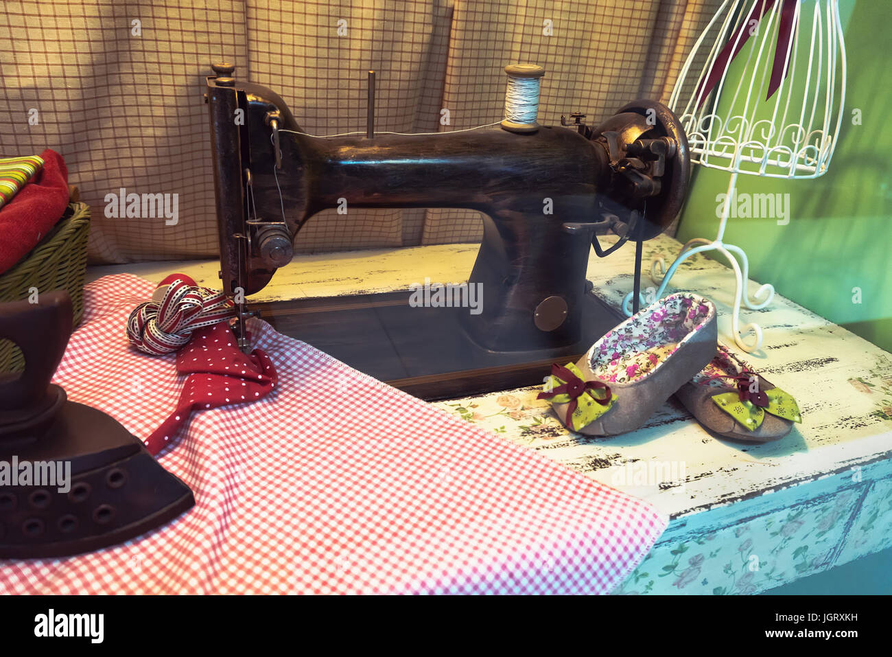 Old tailor with sewing machine, fashion dummy and cloth