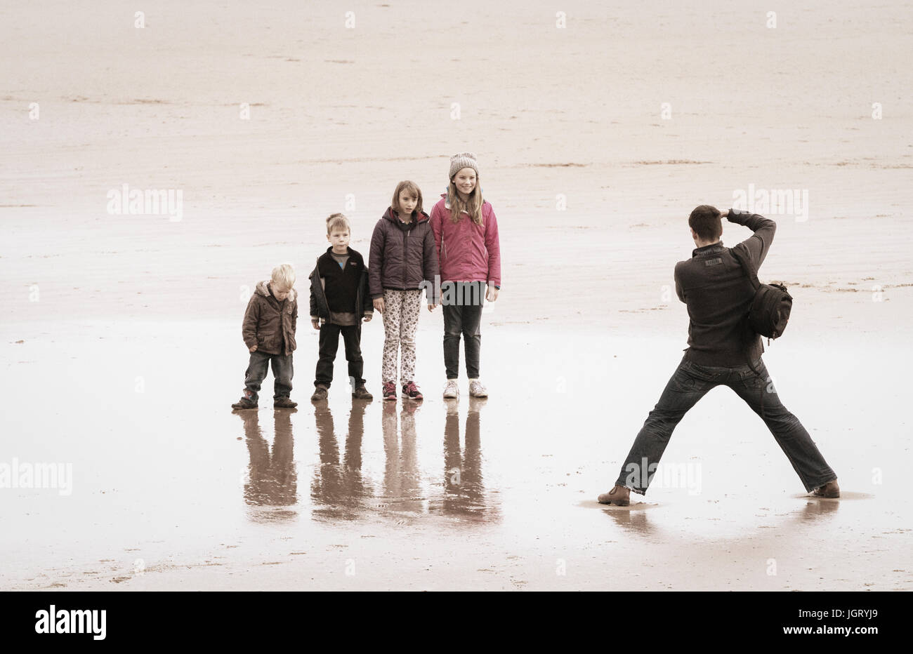 Children having photo taken on beach. UK Stock Photo