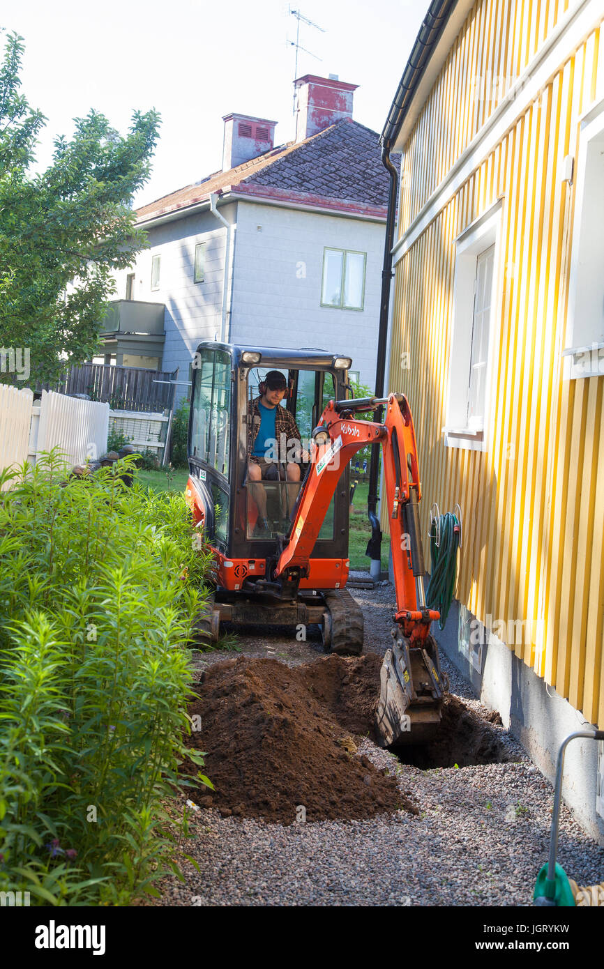 EXCAVATOR in garden digging for mountain heath 2017 Stock Photo