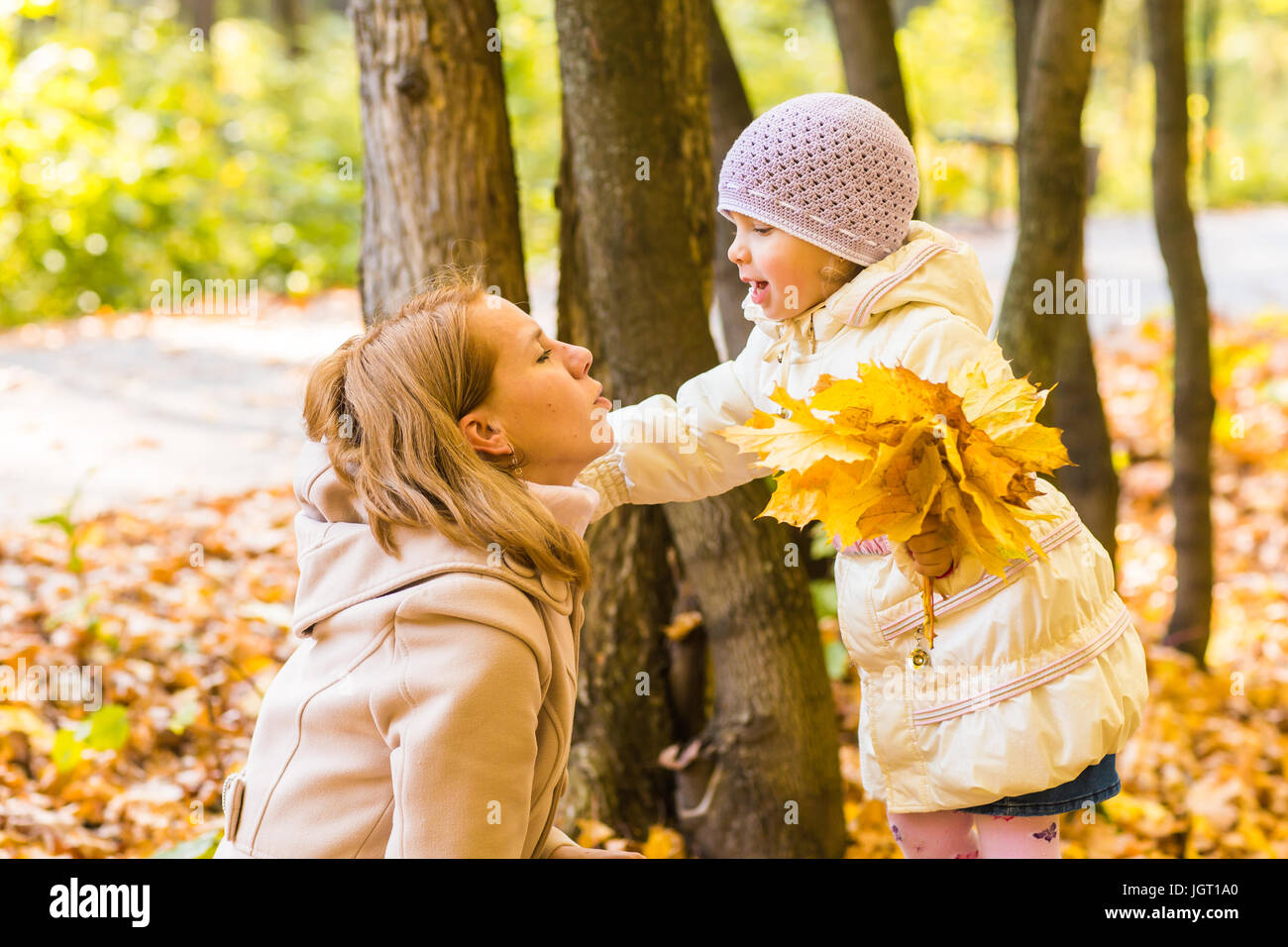 Young mother playing with her daughter in autumn park Stock Photo - Alamy