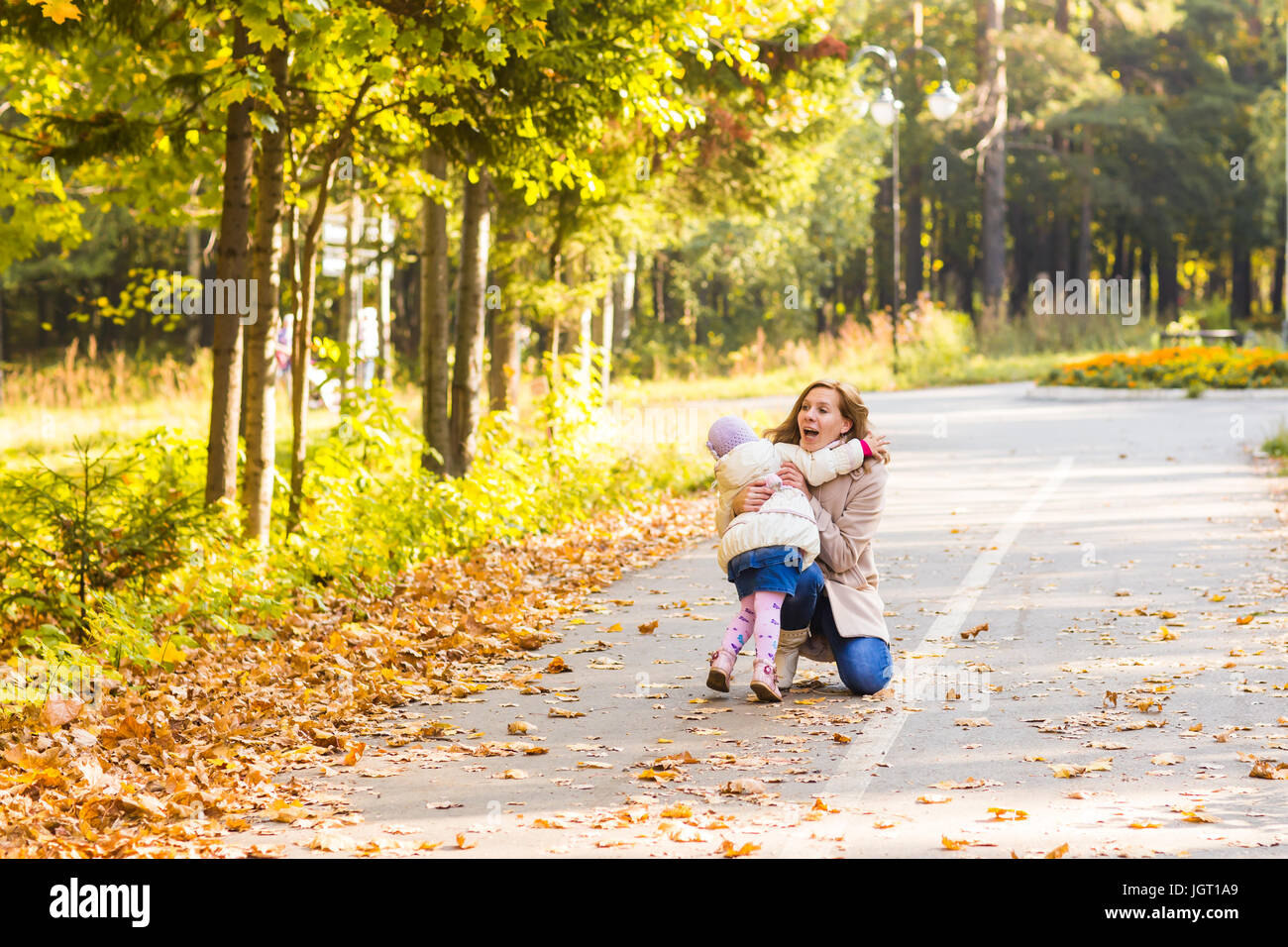 Young mother playing with her daughter in autumn park Stock Photo - Alamy