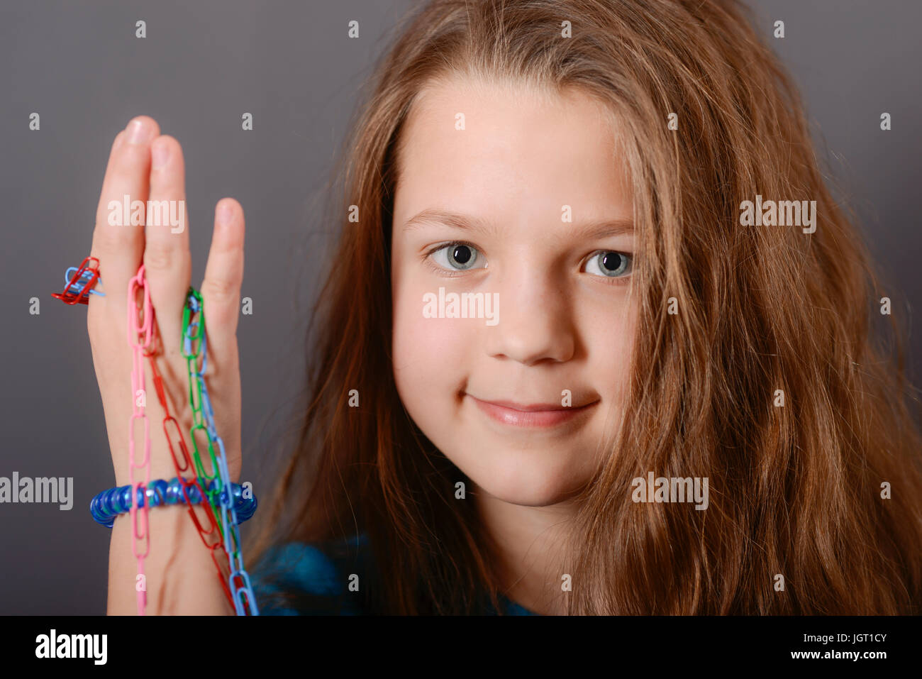 smiling child girl with handmade color clips chain in hand Stock Photo