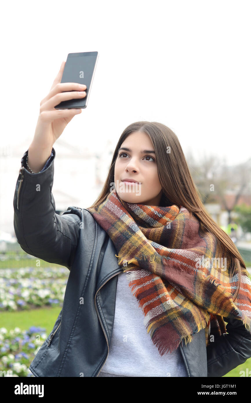 Portrait of a young beautiful woman taking selfie with her smartphone ...