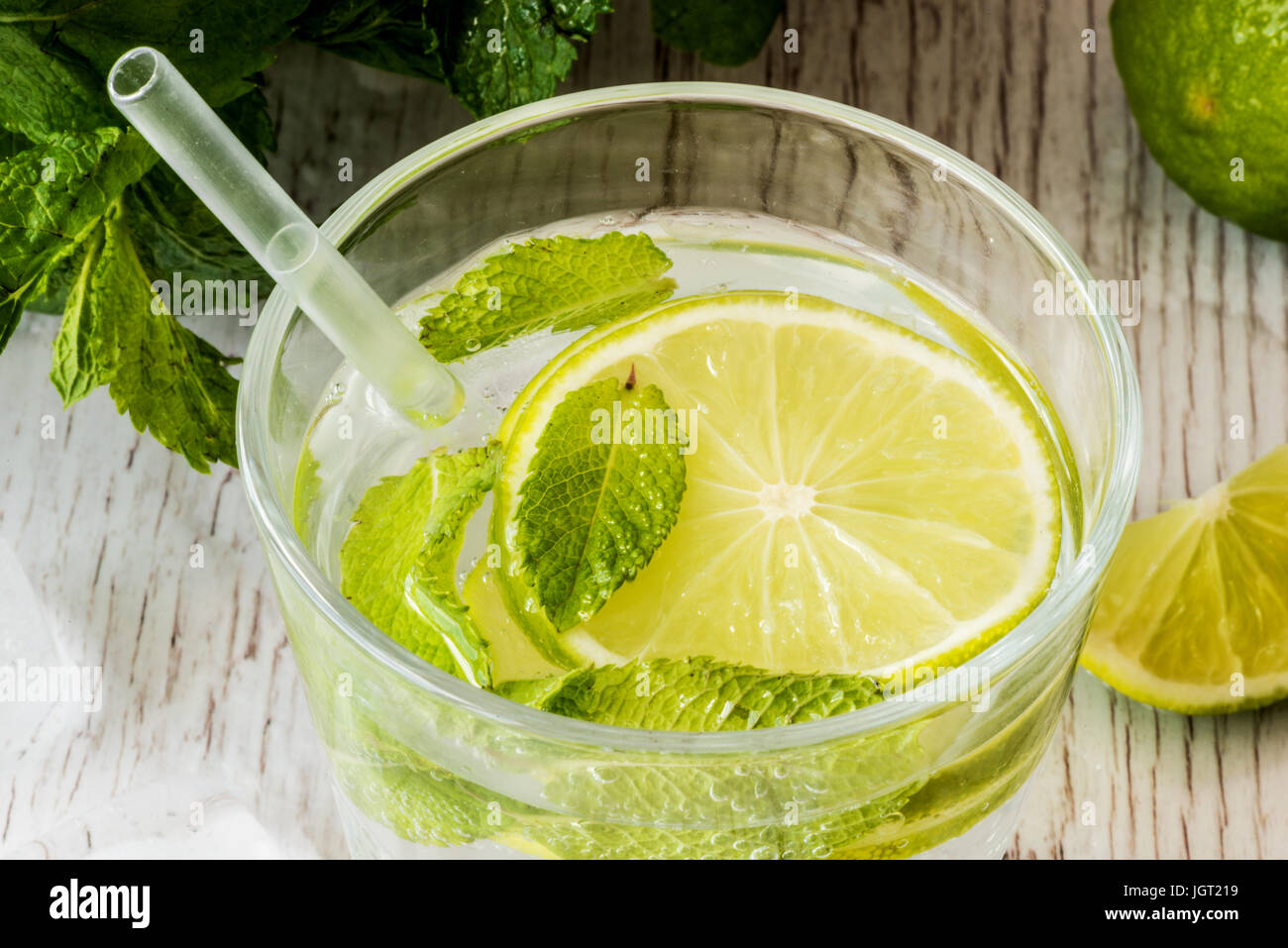 https://c8.alamy.com/comp/JGT219/mojito-cocktail-with-lime-mint-and-ice-on-white-wooden-background-JGT219.jpg