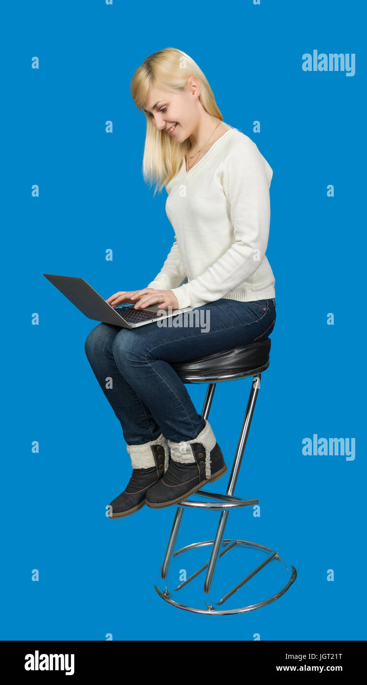 Business woman sitting a high chair and works on the laptop Stock Photo