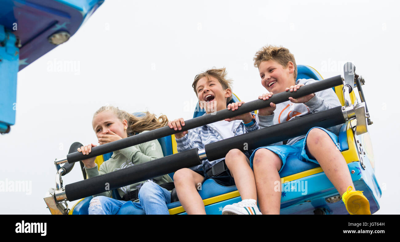 Young friends riding on the Galaxia ride on Brighton Pier in the Summer. Stock Photo