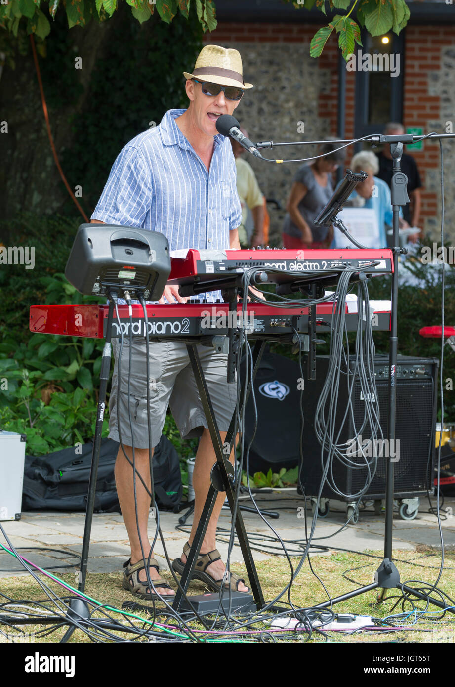 Man in a music band standing outside playing the keyboard. Stock Photo