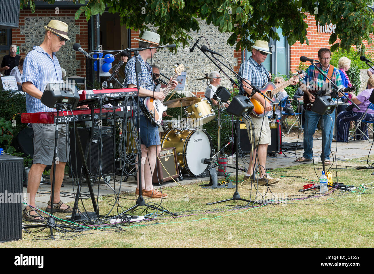 Music band at a charity gig standing while playing outside. Stock Photo
