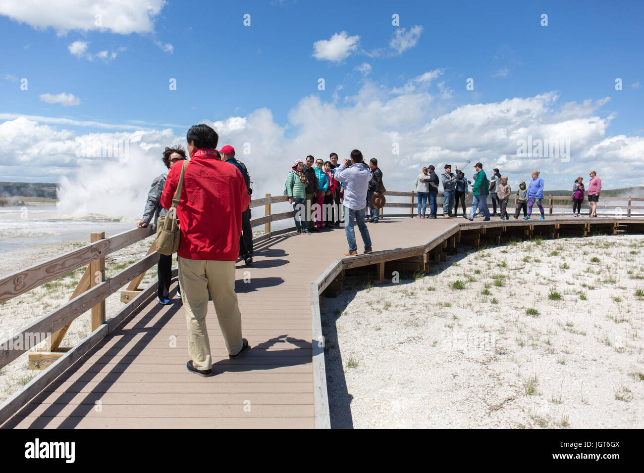 People are taking pictures and making selfies on the boardwalk of Fountain Paintpot Trail near Spasm Geyser in Lower Geyser Basin in Yellowstone Natio Stock Photo