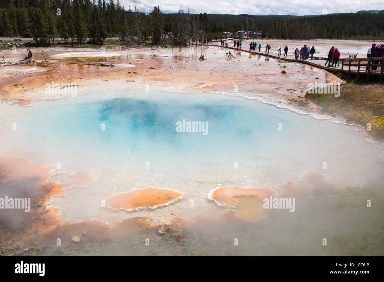 People are walking on the boardwalk of Fountain Paintpot Trail next to Silex Spring in the Lower Geyser Basin in Yellowstone National Park Stock Photo