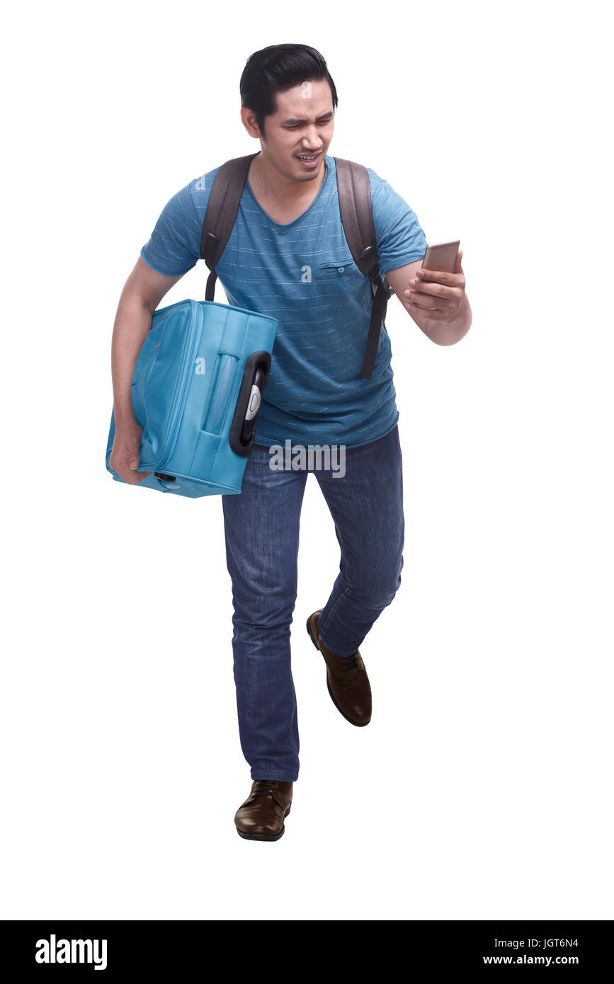 Portrait of hurry asian traveler running with carrying suitcase isolated over white background Stock Photo