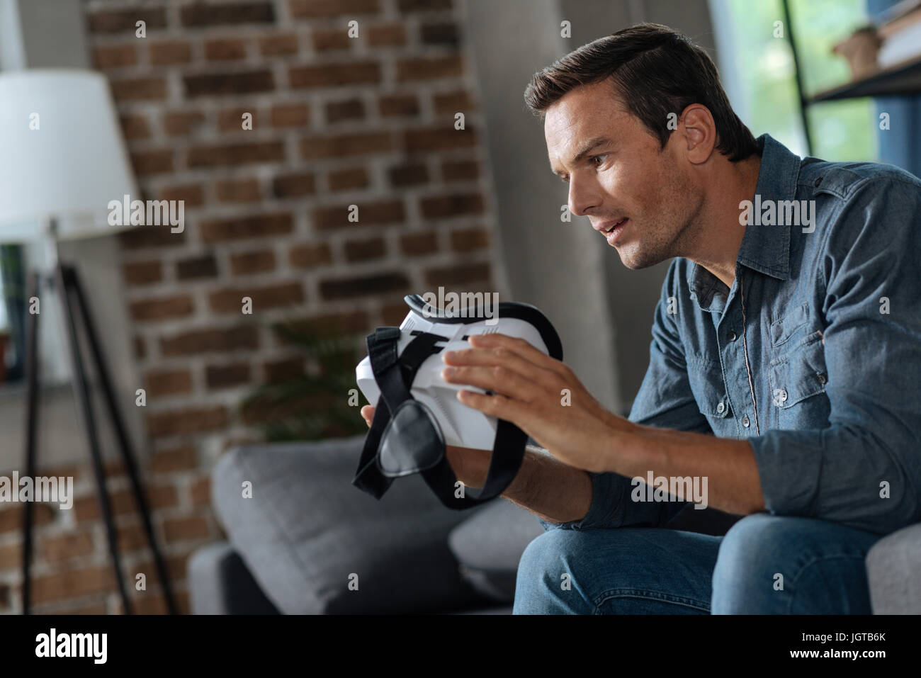 Sincere smart guy fascinated with his new device Stock Photo