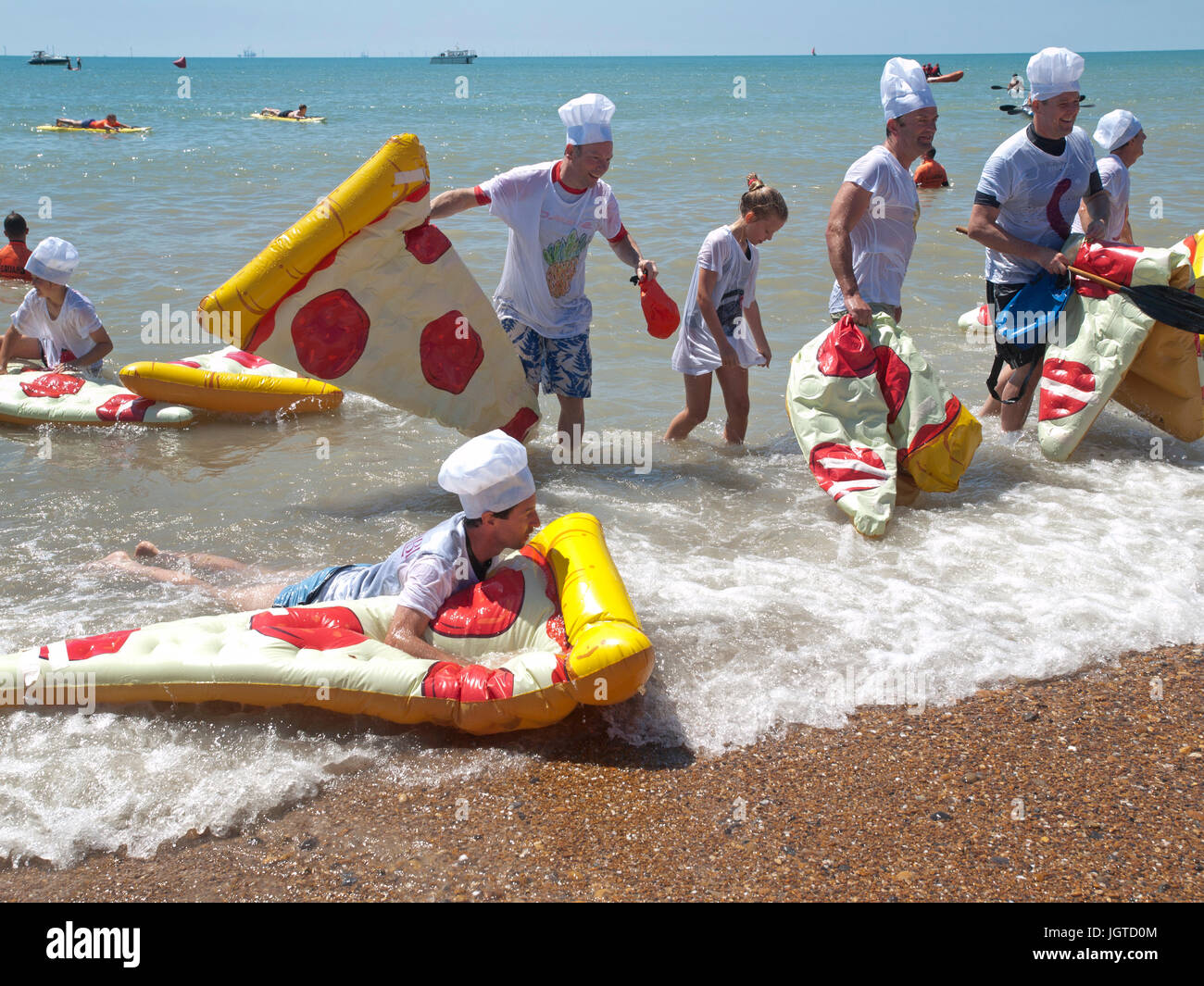 A pizza and chefs themed team in the Paddle Around The Pier event, held yearly in Brighton Stock Photo