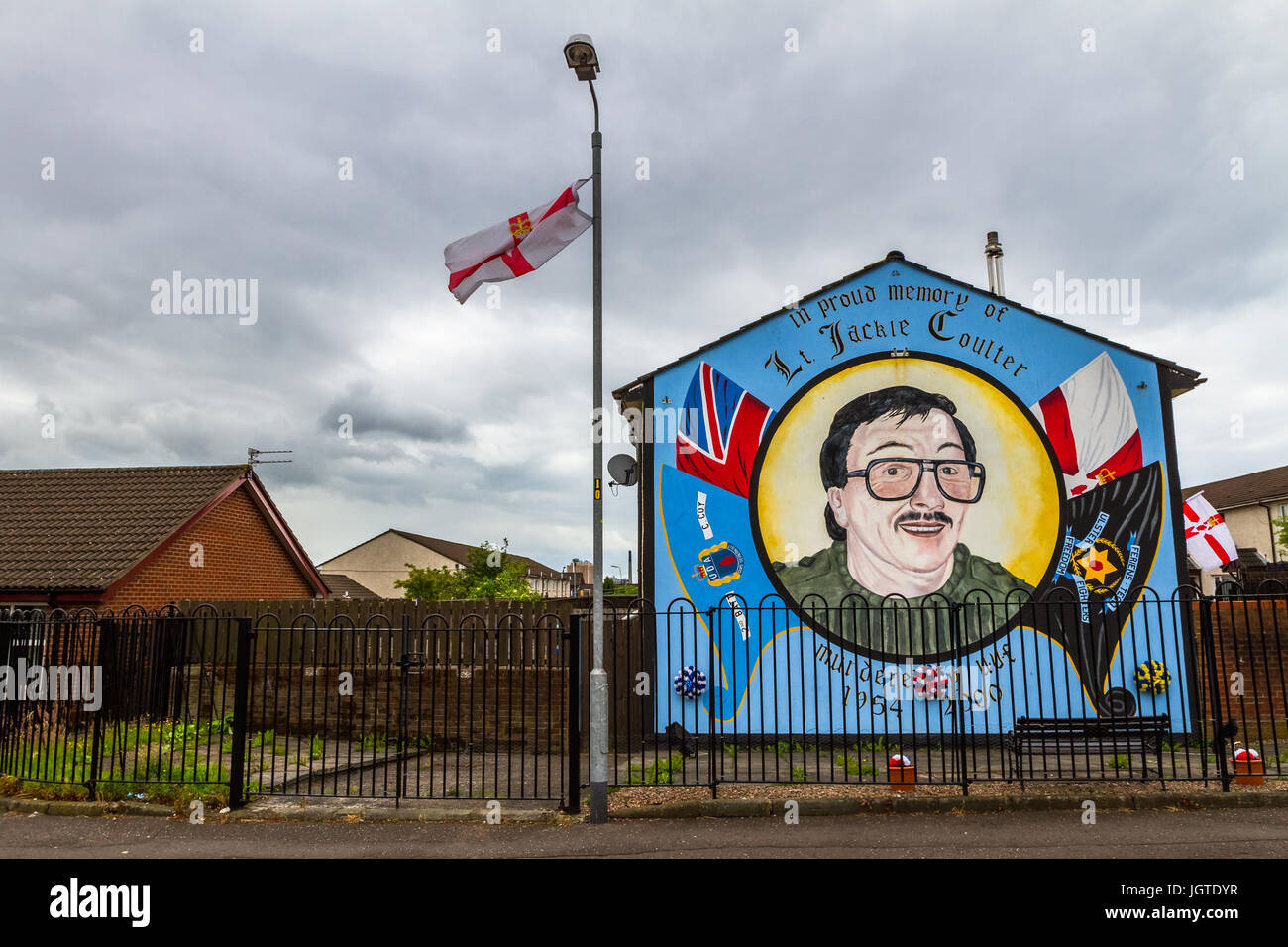 The Ulster Banner flies in front of a mural in a loyalist neighborhood in Belfast, Northern Ireland. Stock Photo