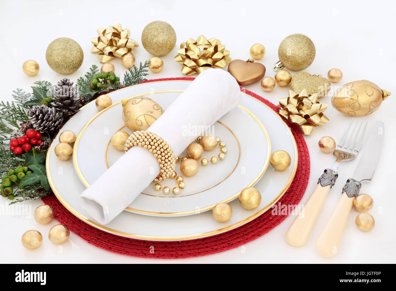 Christmas dinner table setting with porcelain plates, napkin, gold