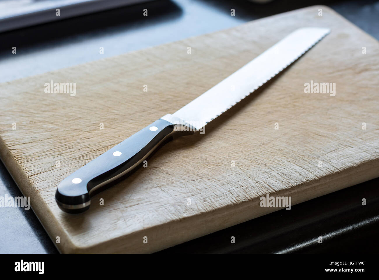 Knife on a wooden cutting board in the kitchen close up Stock Photo - Alamy
