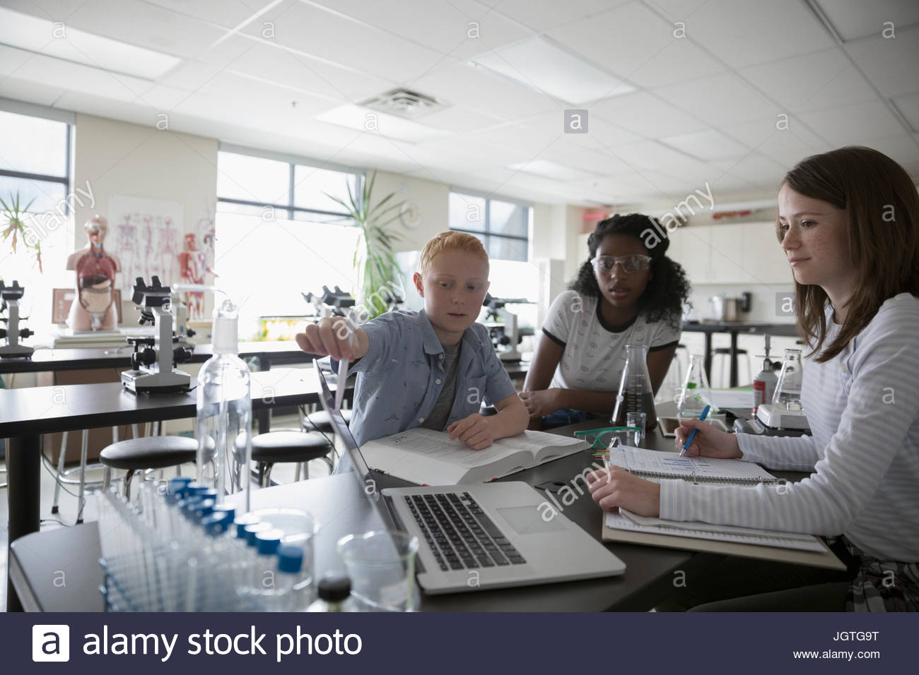 Middle school students conducting scientific experiment in science