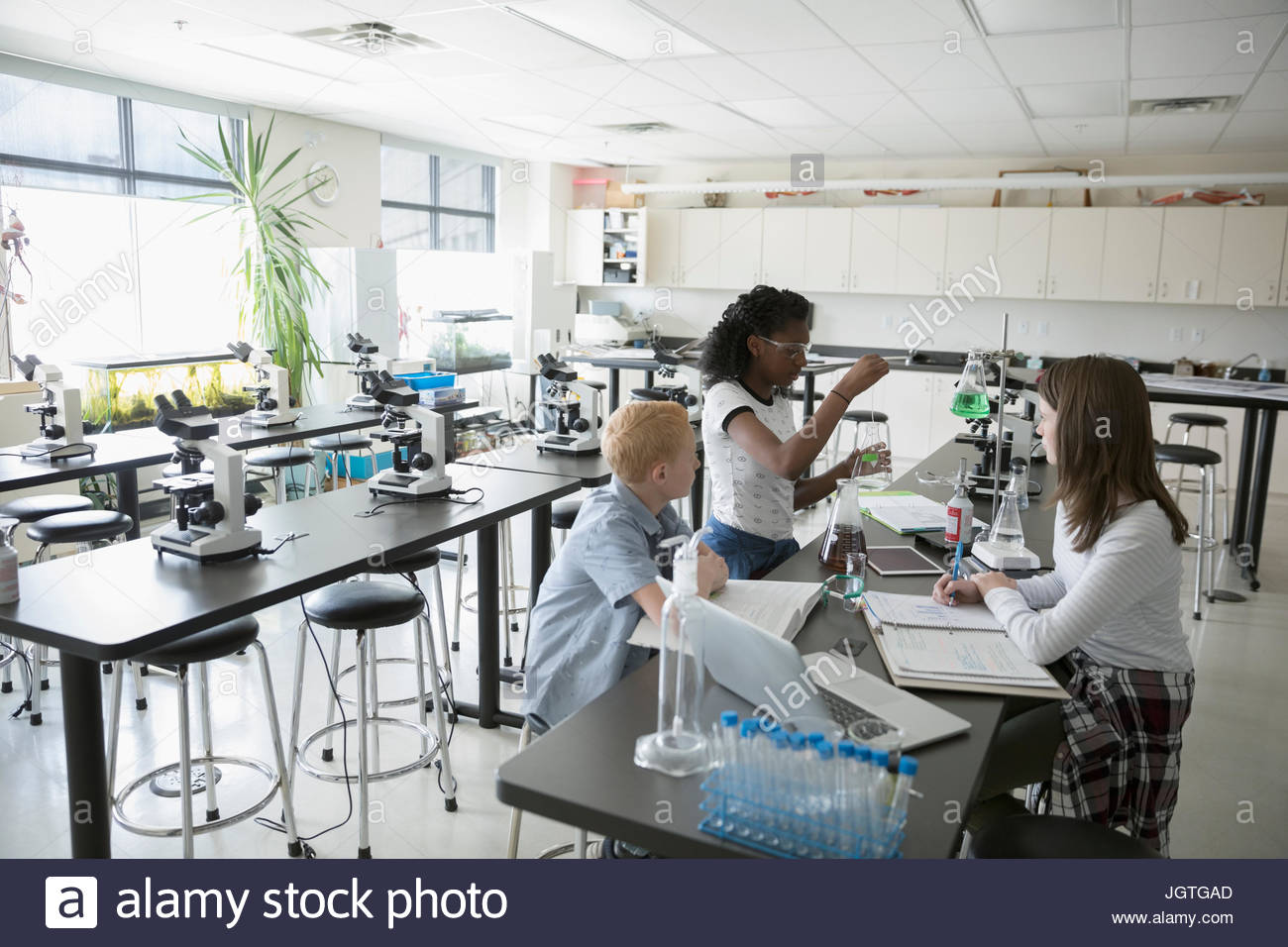 Middle school students conducting scientific experiment in science