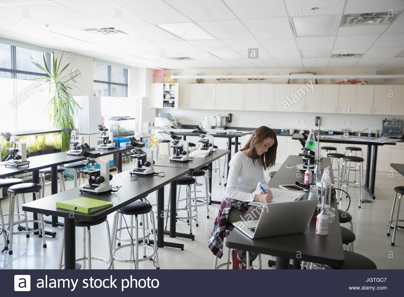 Girl middle school student conducting scientific experiment in science