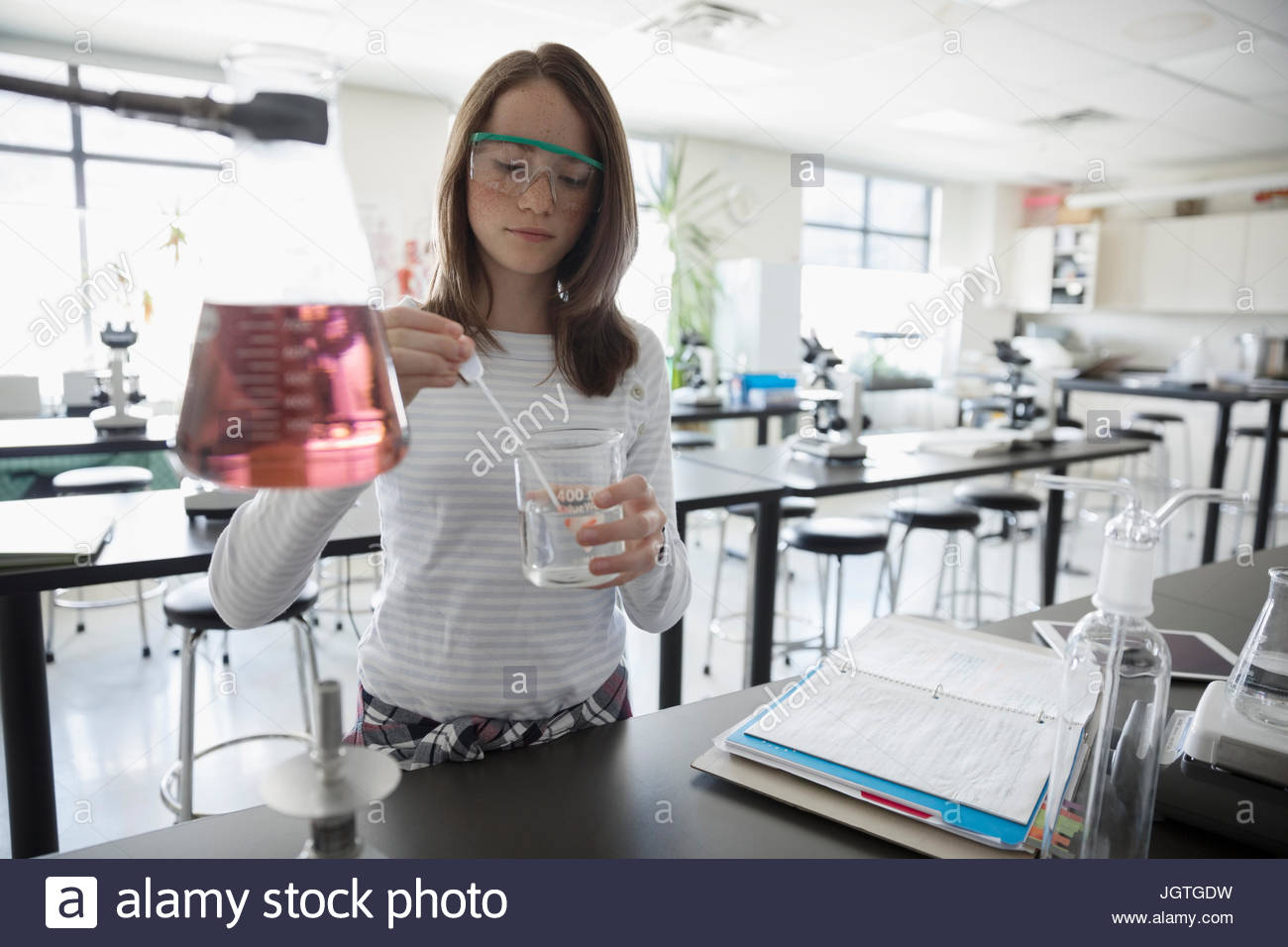 Girl middle school student conducting scientific experiment in science