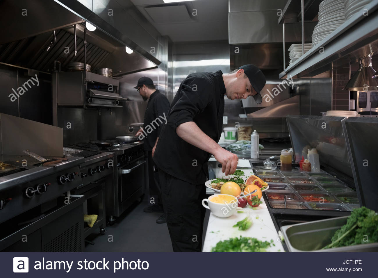 Line cook preparing food in restaurant kitchen Stock Photo - Alamy