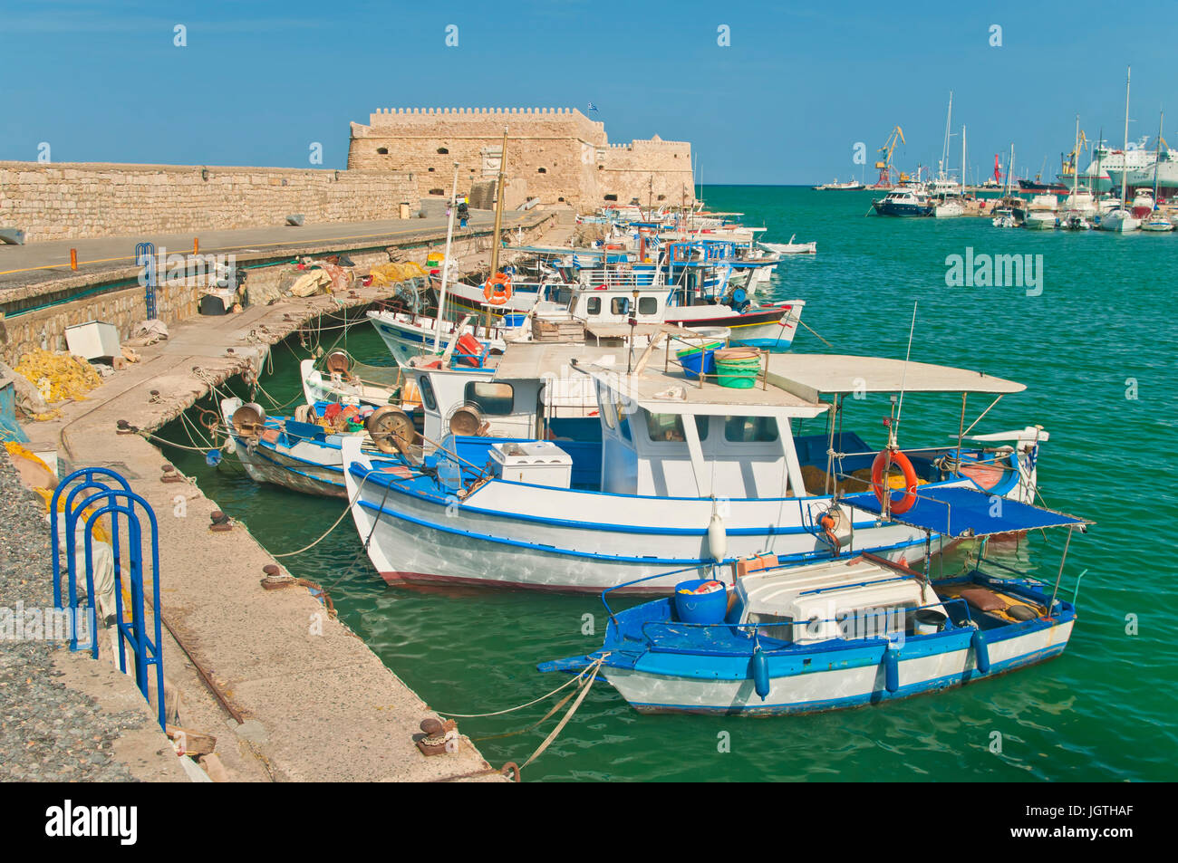 small blue and white fishing boats moored at Koules Fortress in Heraklion, Crete, Greece Stock Photo