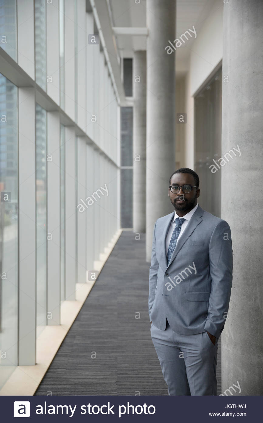 Portrait serious businessman in suit standing in modern office Stock ...