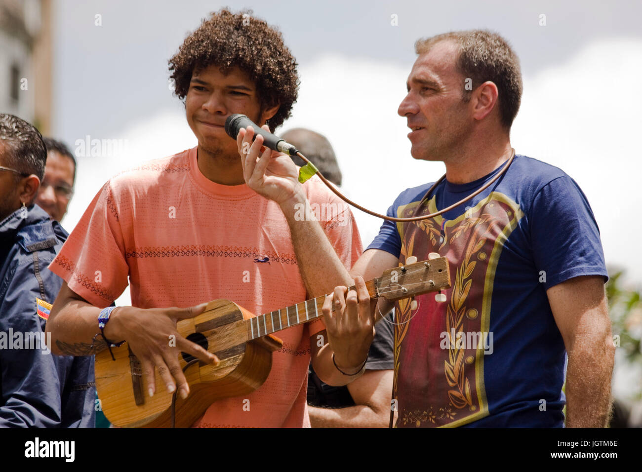 A young demonstrator sings and plays a cuatro during a protest against the government of Nicolás Maduro. Stock Photo