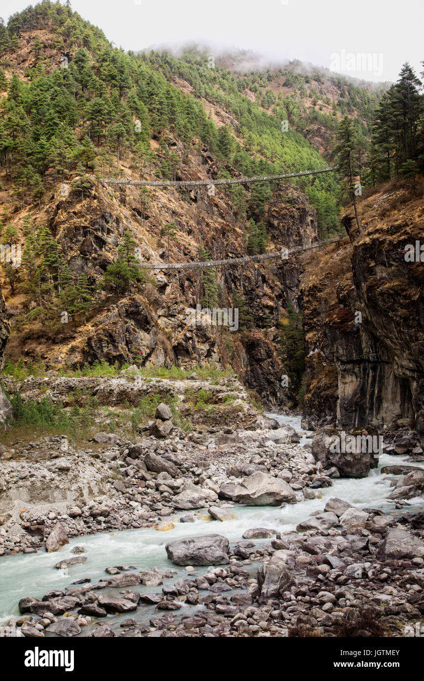 The Larja cable suspension bridge spans the Dudh Koshi Nadi River on the trail to Namche in the Khumbu region.  Sagarmatha National Park, Nepal. Stock Photo