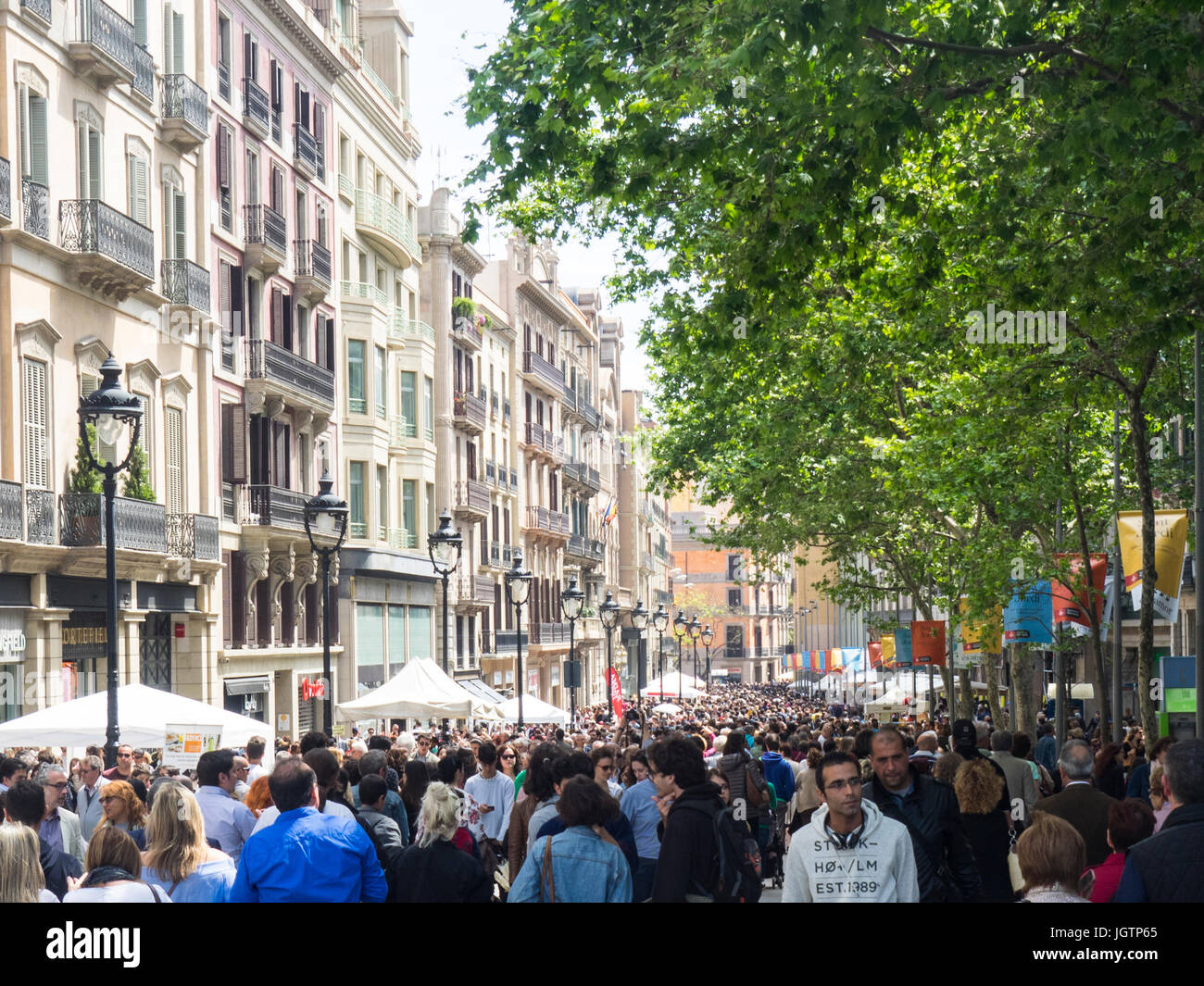 Crowds op people walking along Avinguda del Portal de l'Àngel on Sat Jordi Day, Barcelona, Spain. Stock Photo