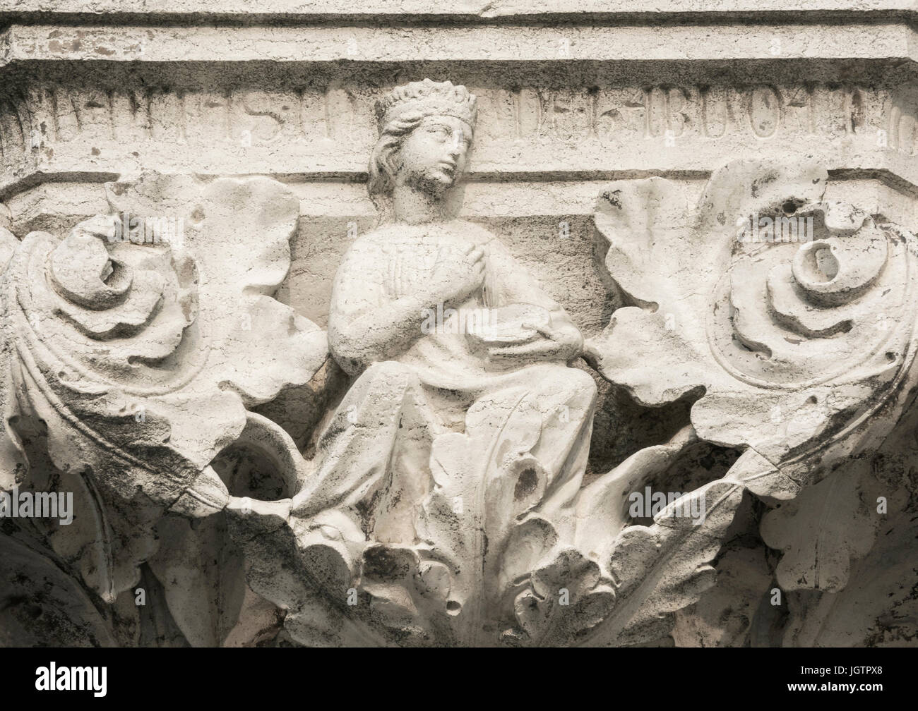 Queen, Princess or Damsel with tambourine, ancient medieval relief on Venice Doge Palace column Stock Photo