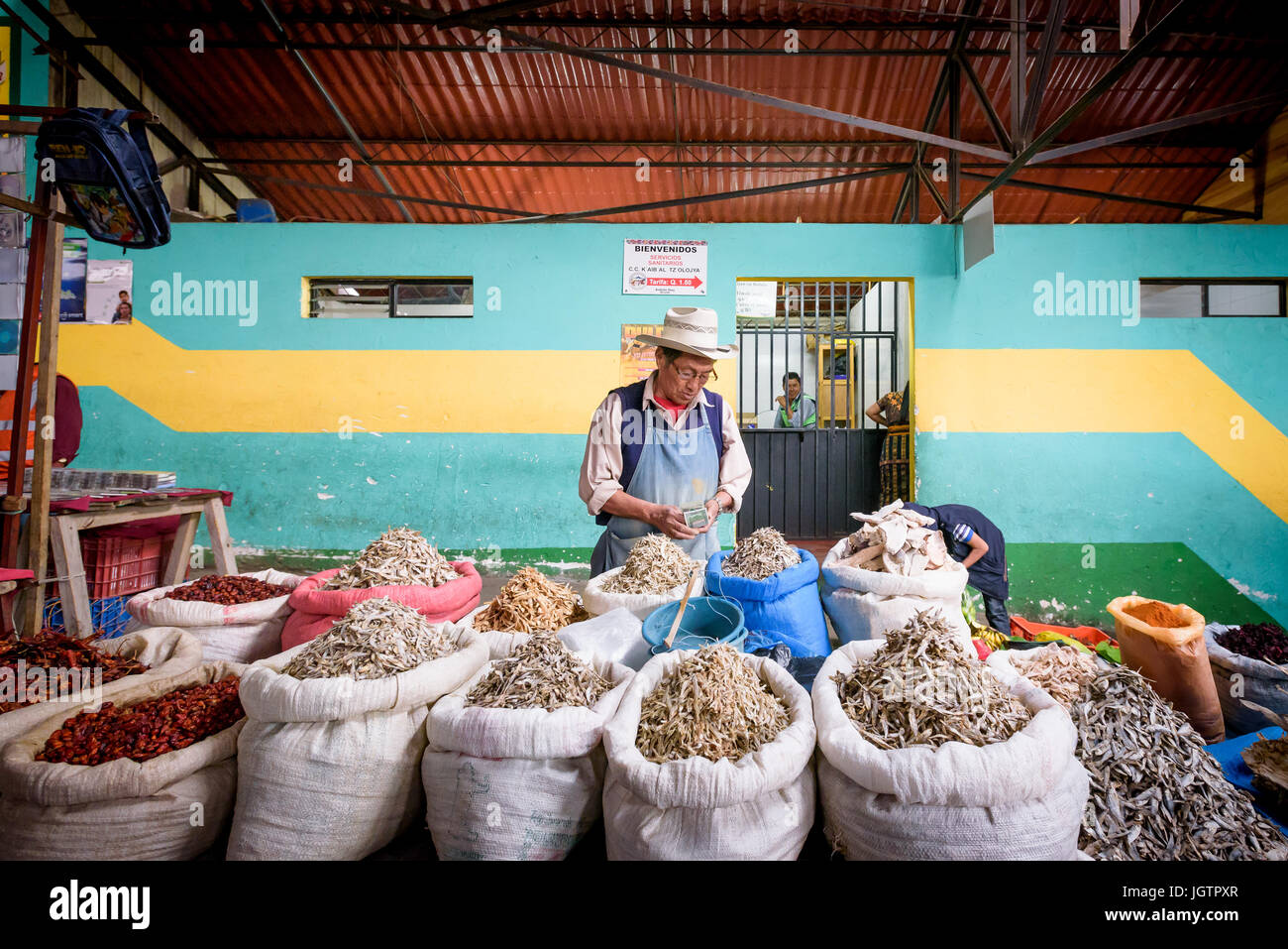 A man counting money inside the main food market (meat, dried fish and vegetable) in Chichicastenango, Guatemala Stock Photo