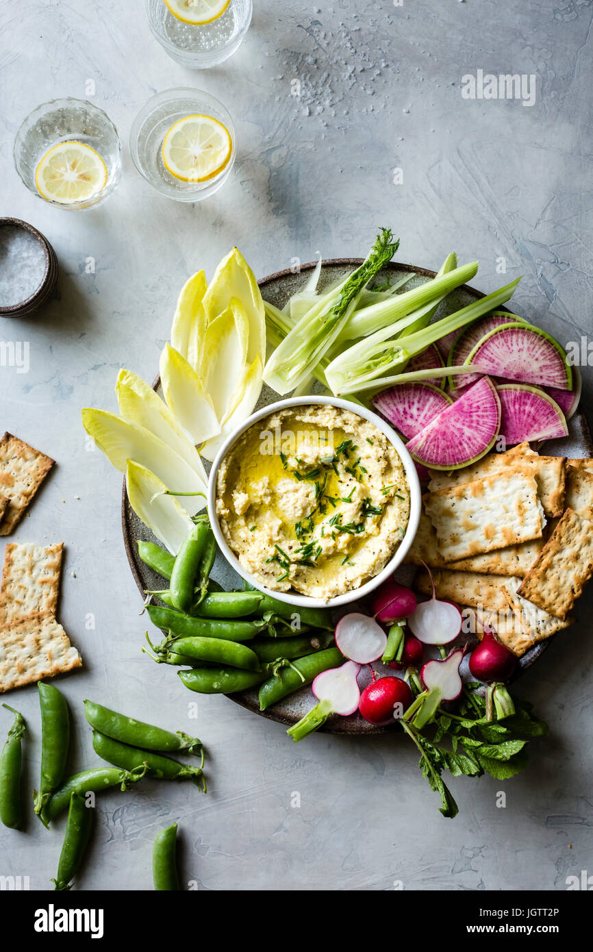 Spring vegetables and hummus on a platter Stock Photo
