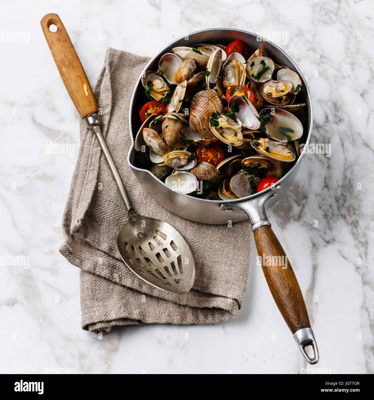 Vongole Shells Clams with tomato and parsley in cooking pan on white