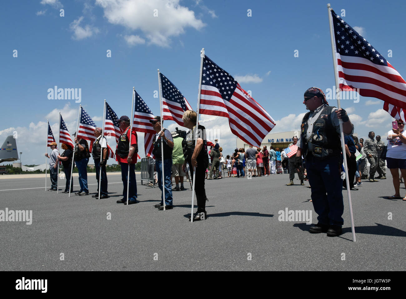Members of the Patriot Guard, a National Motorcycle group form up at the exit to the flight line of the North Carolina Air National Guard, in order to salute and greet North Carolina Air National Guardsman returning from deployment, at the North Carolina Air National Guard Base, Charlotte Douglas International Airport, July 5th, 2017. The riders of the Patriot Guard arrived on base to help welcome back and honor the deployed Airmen of the 145th Airlift Wing, who returned home after months overseas supporting Operation Freedom’s Sentinel. Stock Photo