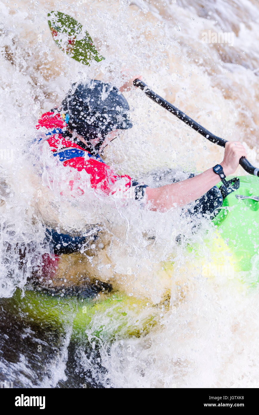 Male Kayak paddler in white water  performing a pirouette in a stopper wave on the Tees Barrage Whitewater Course in Spring Stock Photo
