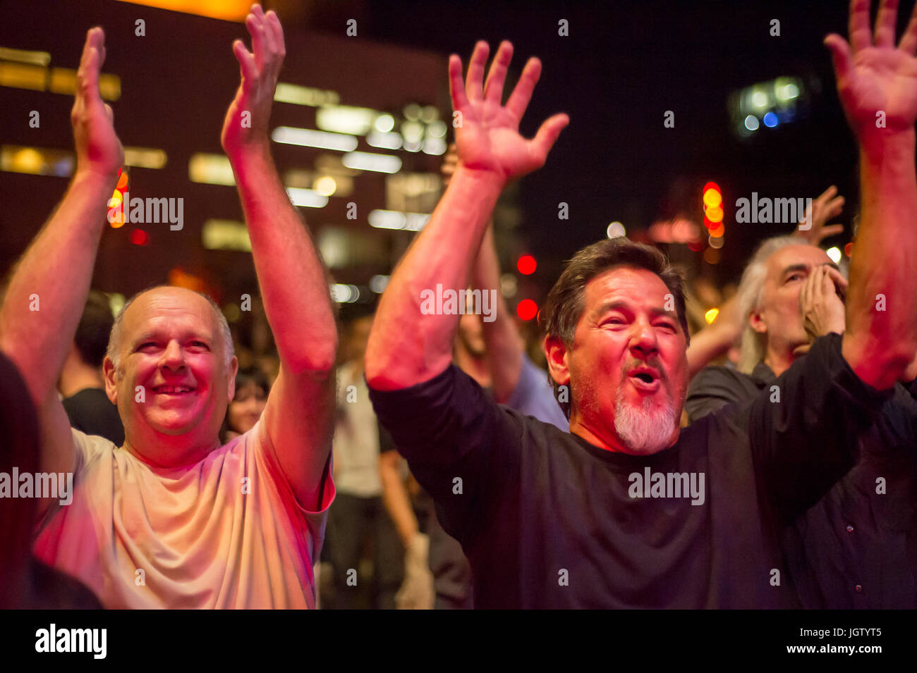 Montreal, 4 July 2017: Men cheering and smiling at the end of a concert at Montreal Jazz Festival Stock Photo