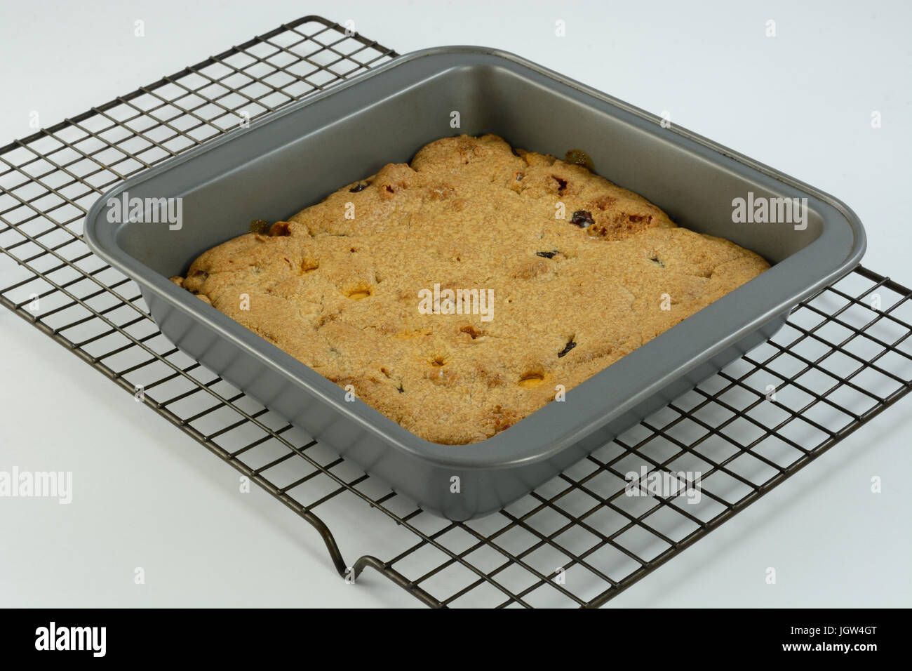 Pumpkin spice blondies with dried cranberries, caramel bits and marshmallow bits in baking pan on cooling rack Stock Photo