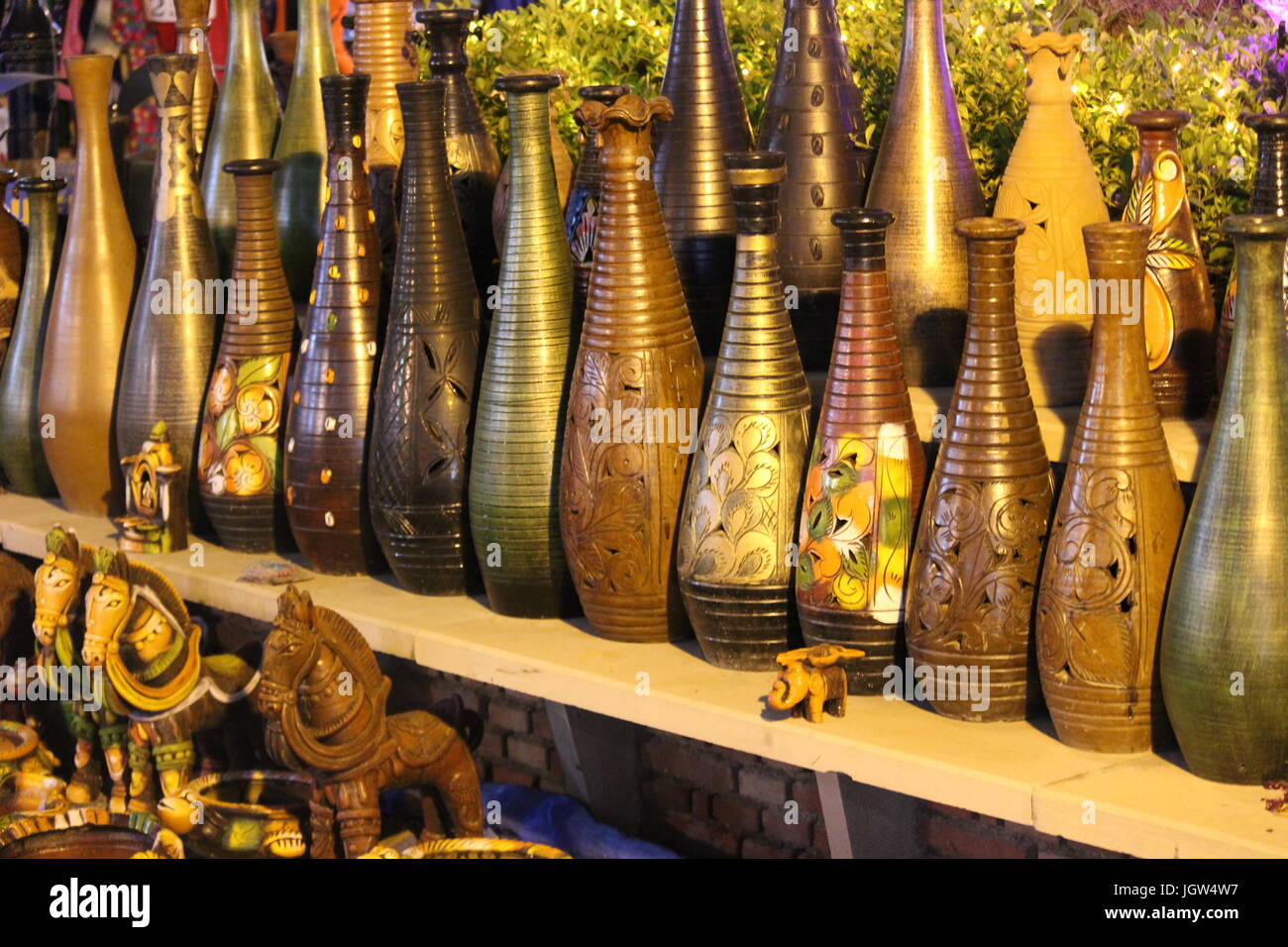 Hand made Flower vases and animals for sale at Dilli Haat, Pitampura, Delhi shining under the lights at night Stock Photo