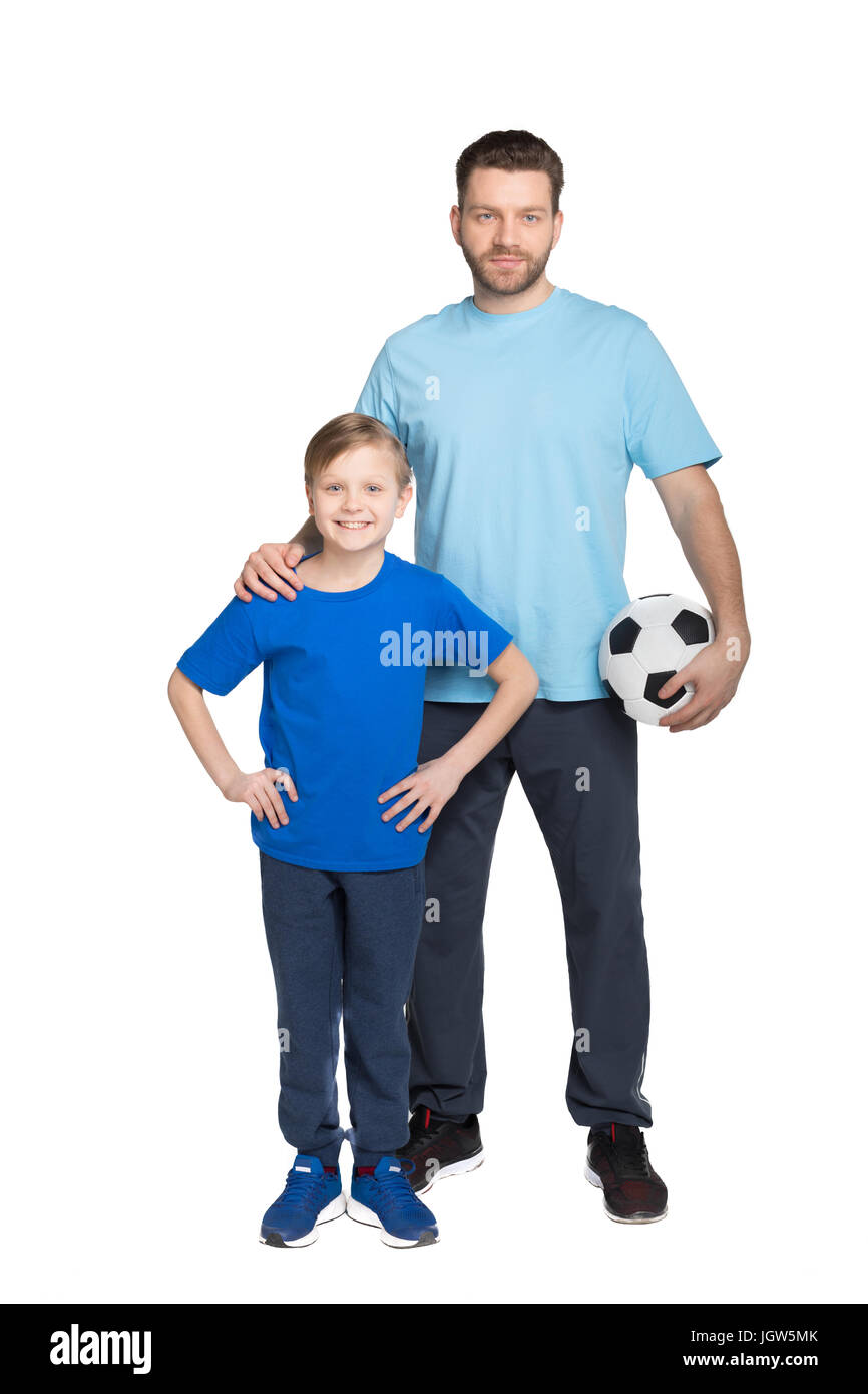 Smiling father and son playing soccer and looking at camera isolated on white Stock Photo