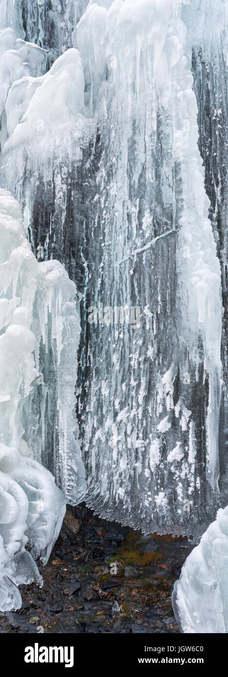 Year around spring water flows into draperies of ice in sub zero temperatures. Stock Photo