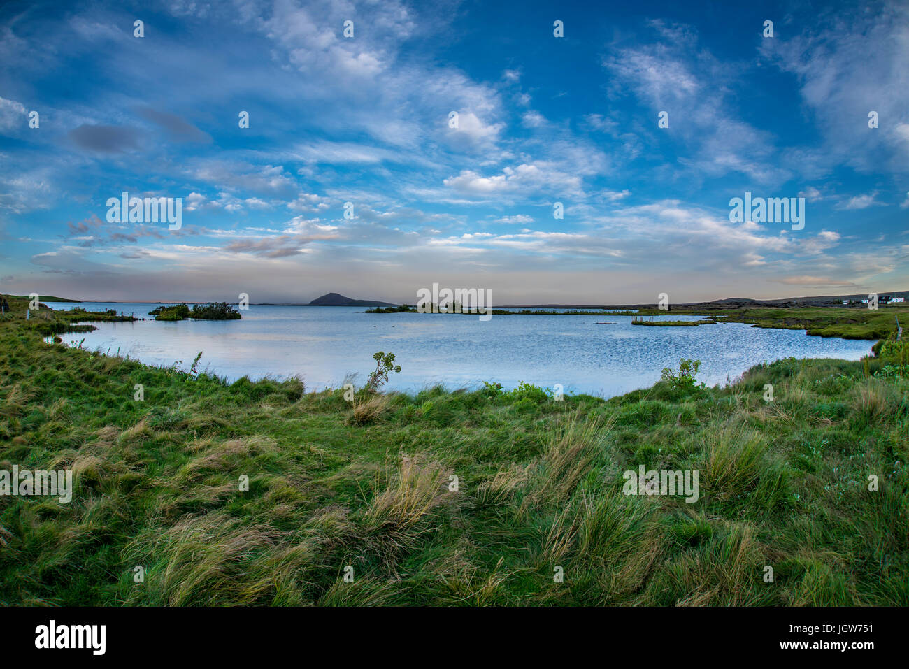 Body of lake water next to a body of grass land Stock Photo