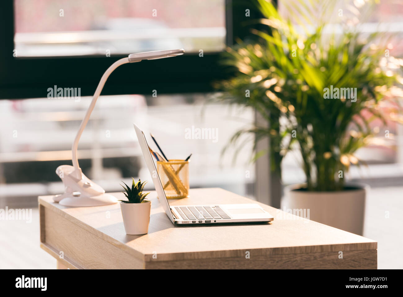 workspace with laptop computer in modern empty office with sunlight Stock Photo