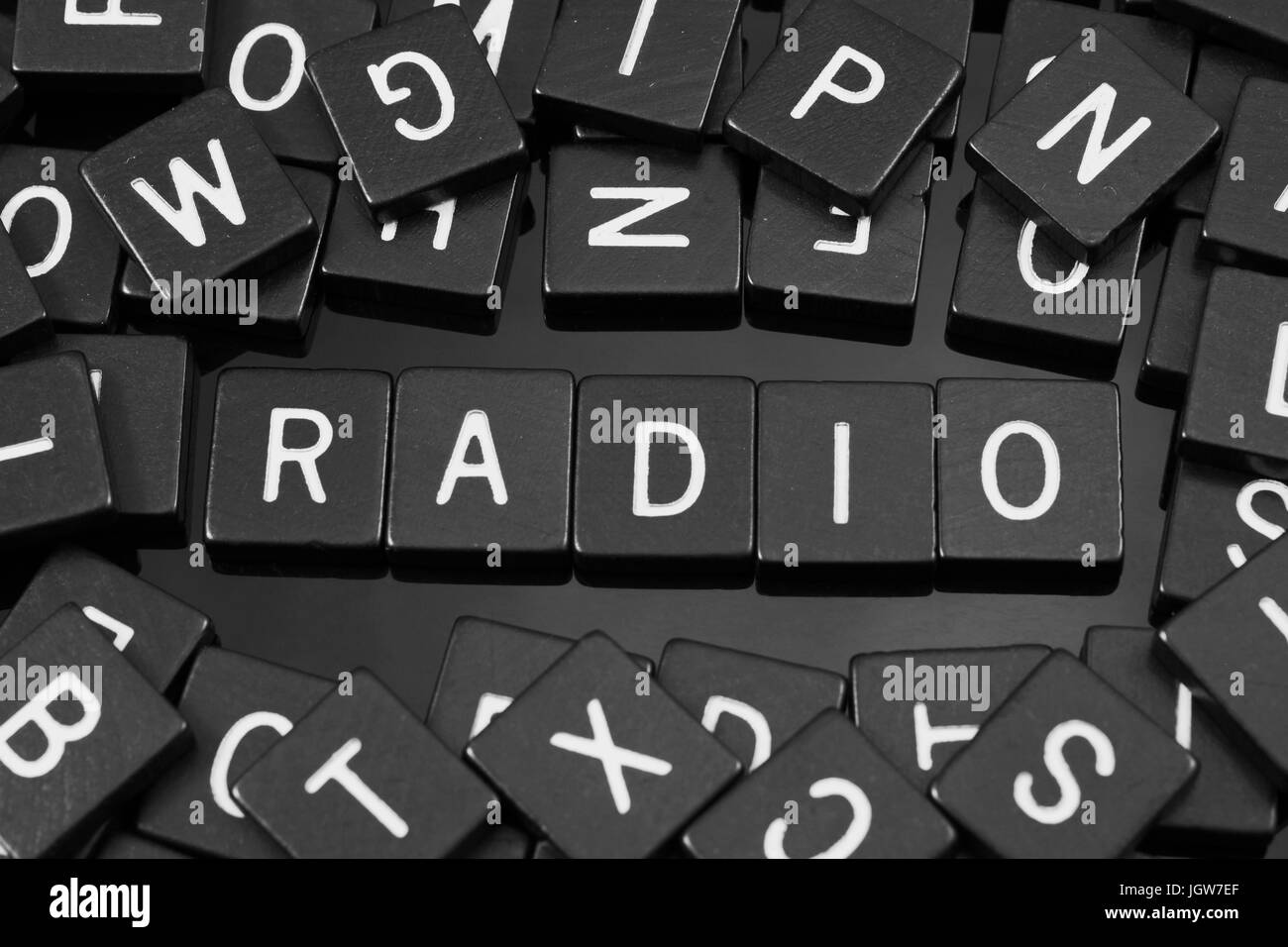 Black letter tiles spelling the word "radio" on a reflective background