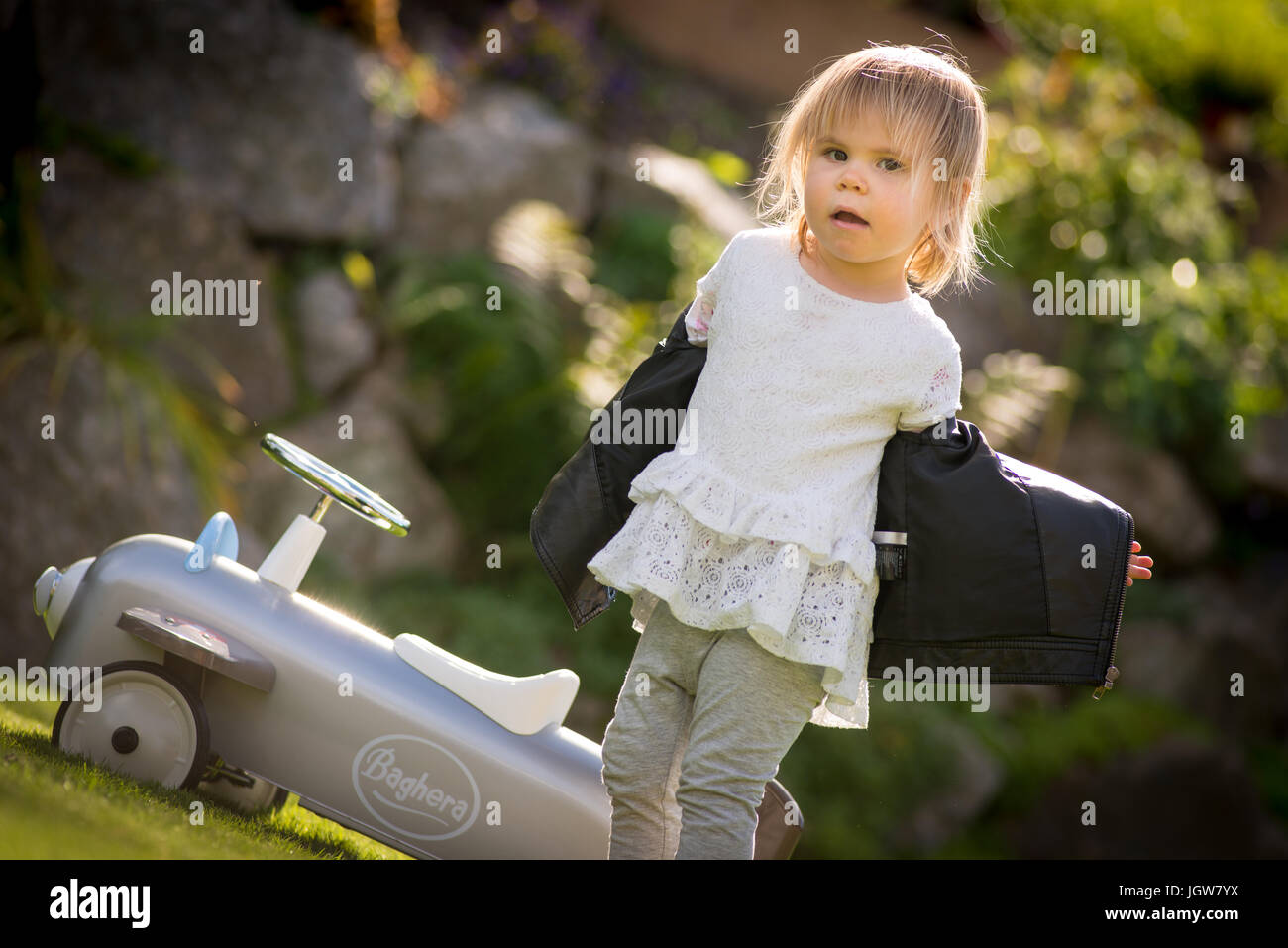 young child  girl taking off jacket after  a toy plane flight Stock Photo