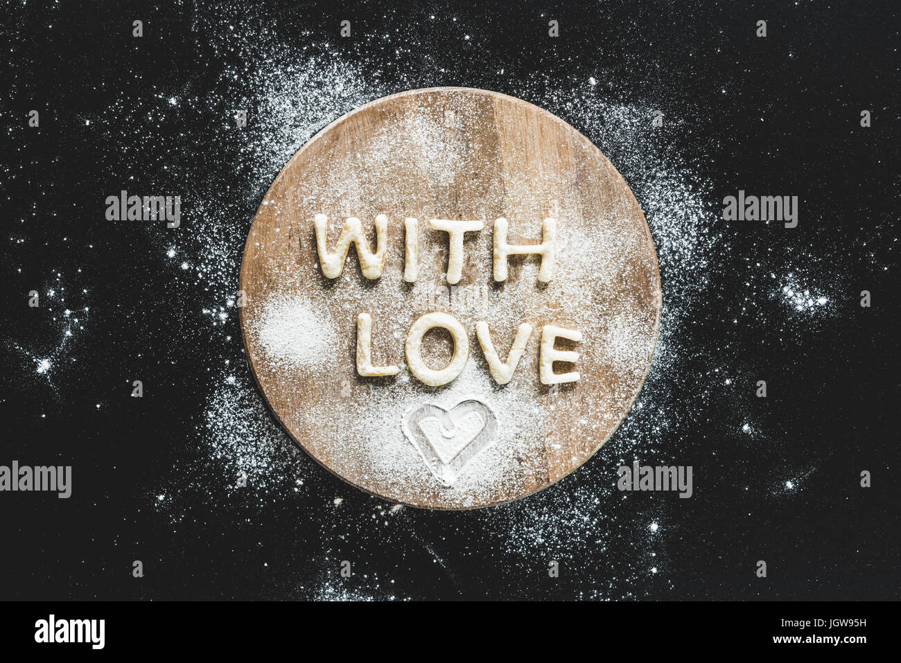 Top view of edible lettering with love from dough on wooden cutting board, baking cookies concept Stock Photo