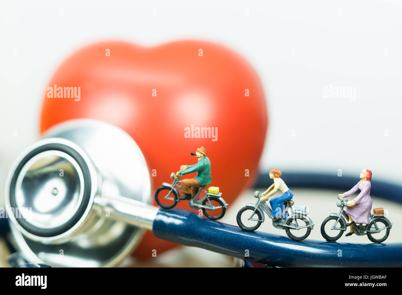 Health and travel insurance, miniature people: small figures riding  on stethoscope and red heart. Business, health care, and traveling concept. Stock Photo