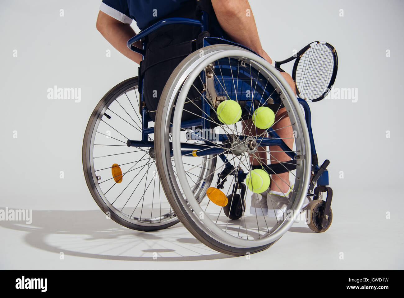 cropped view of tennis player sitting in wheelchair with tennis racquet