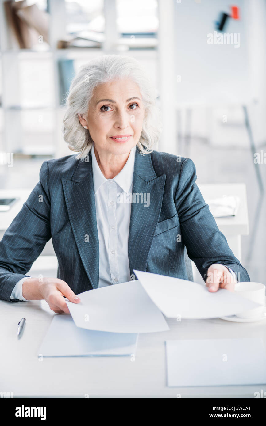 portrait of confident senior businesswoman doing paperwork at workplace