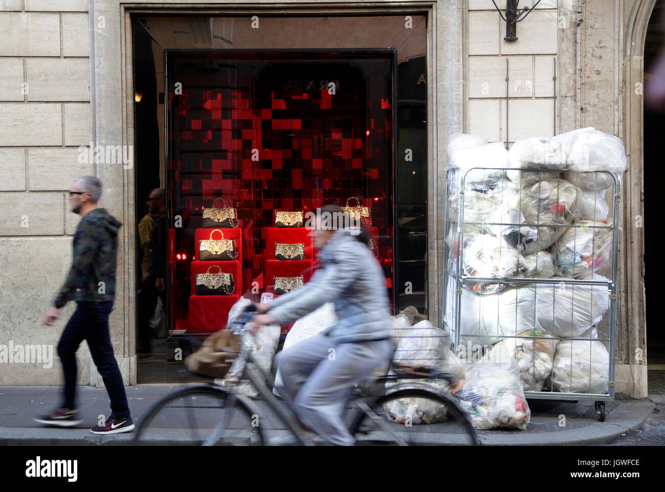 Garbage bags in front of the showcase of a fashion store at Via